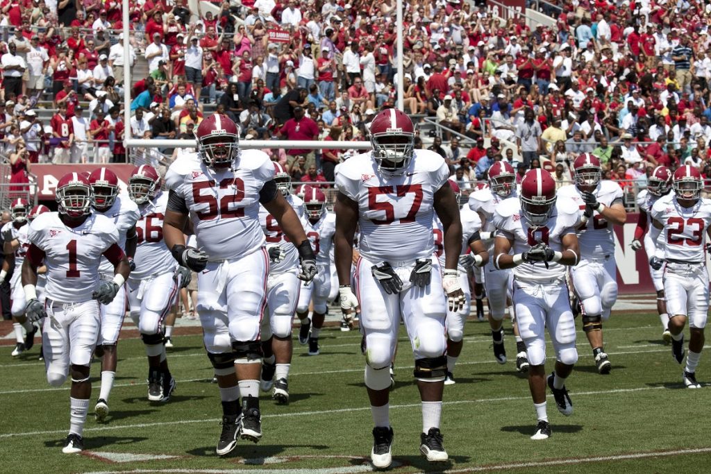 Alabama football team players in action on the field, showcasing their dedication and teamwork
